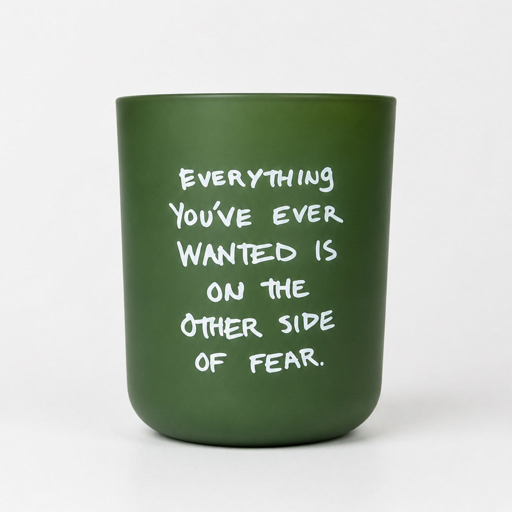 KASE Candle in a frosted green glass vessel reading Everything you’ve ever wanted is on the other side of fear