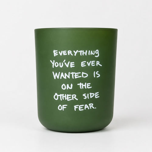 KASE Candle in a frosted green glass vessel reading Everything you’ve ever wanted is on the other side of fear